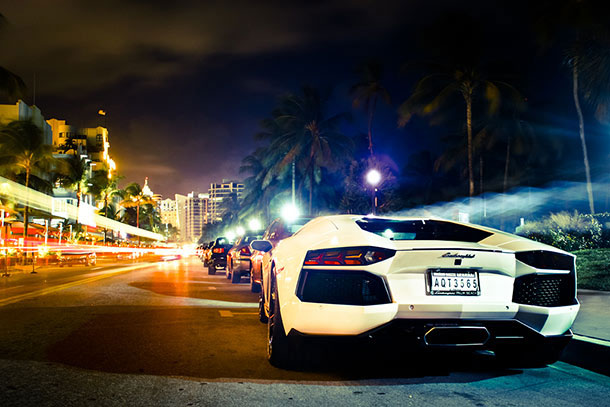 White Lamborghini parked on city street at night