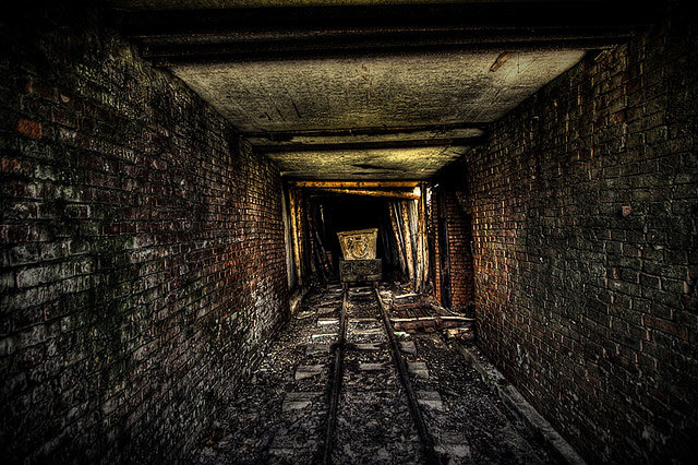 Abandoned mine tunnel with cart on tracks
