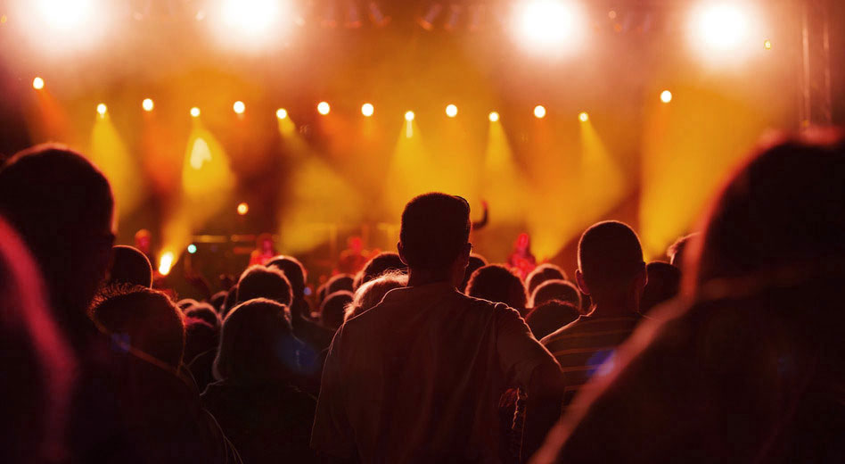Crowd silhouetted against bright concert stage lights