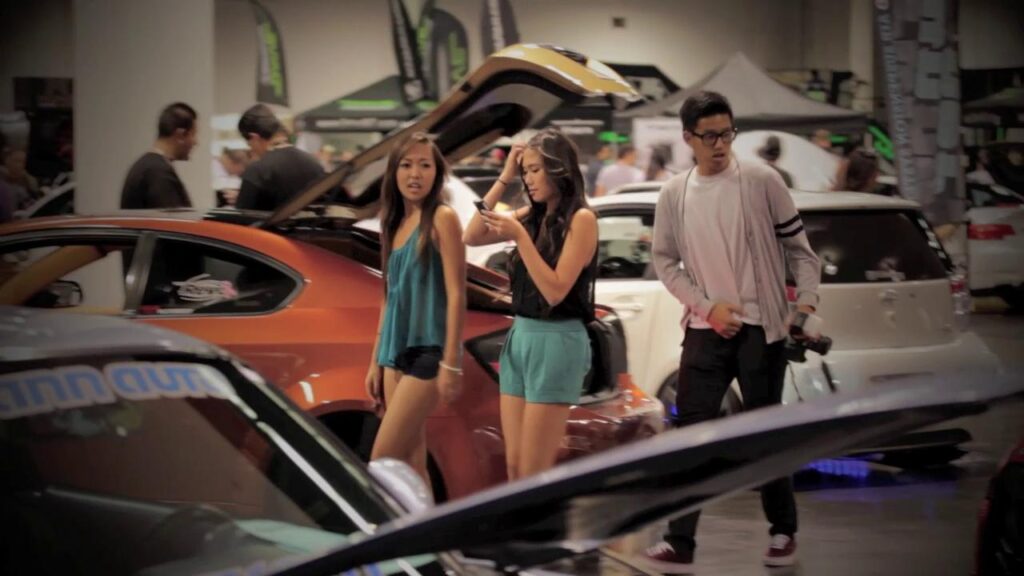 Visitors browsing cars at indoor auto show