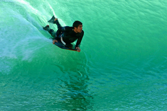 Bodyboarder riding inside green ocean wave