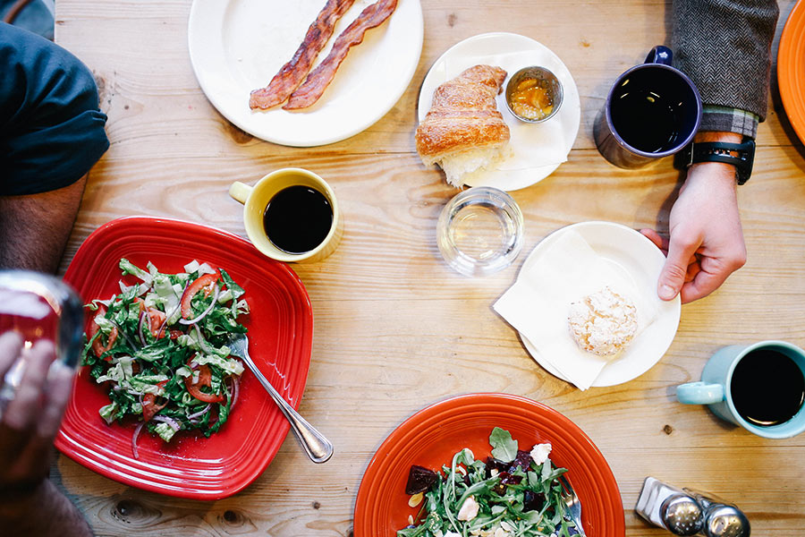 Brunch spread: salads, bacon, croissant, coffee
