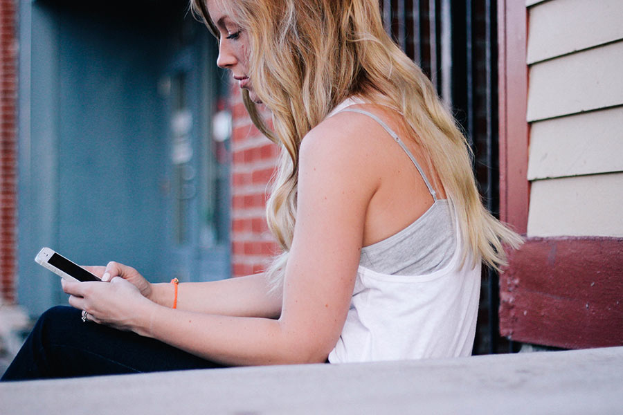 Person sitting on steps using smartphone