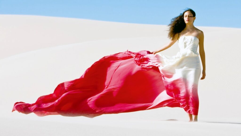 Woman in white dress with flowing red fabric