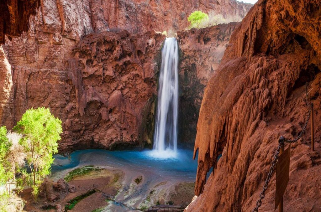 Turquoise pool waterfall in red rock canyon