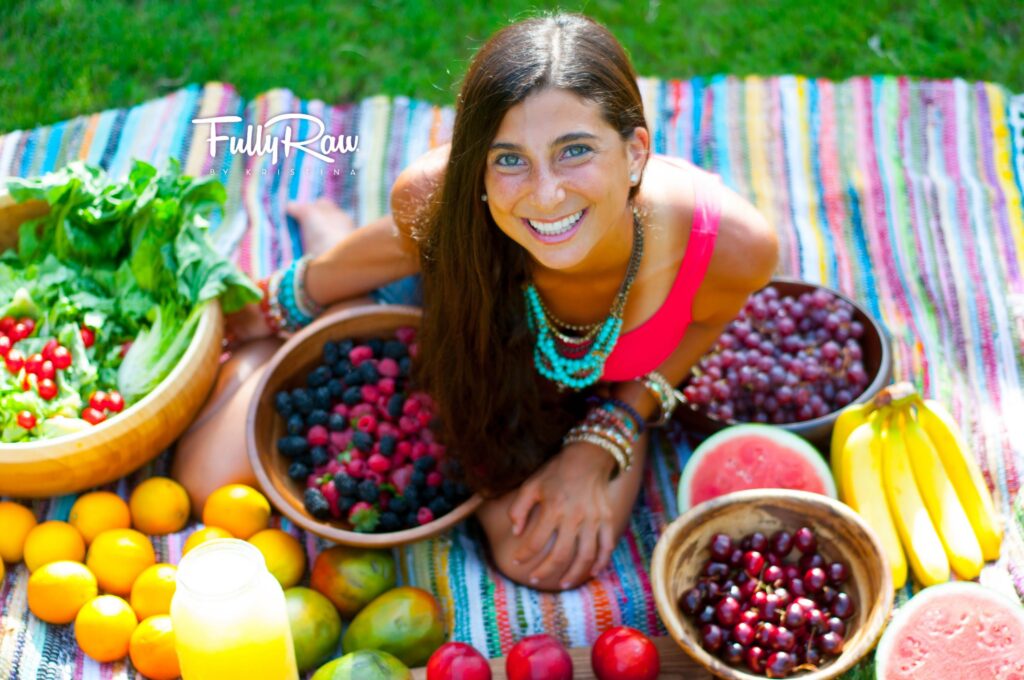 Smiling woman surrounded by colorful fresh fruits