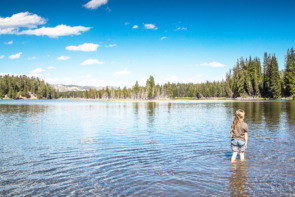 Person wading in clear mountain lake