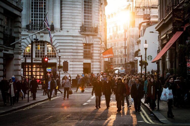 Crowded city street with pedestrians at sunset